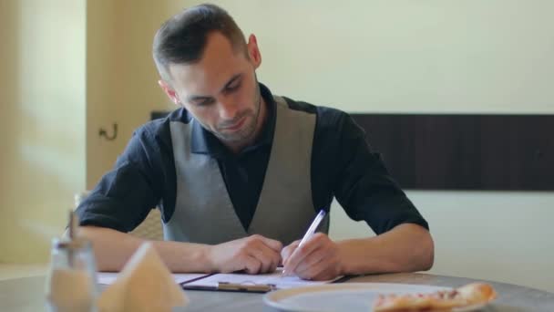 Schöner Mann schreibt ein Dokument in Pizzeria Cafe — Stockvideo