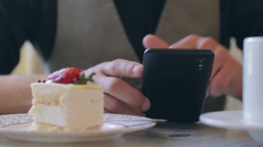 Kahve molası sırasında akıllı telefon kullanan bir müşteri.