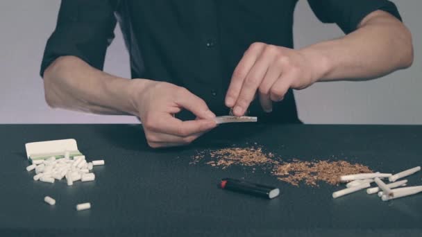 Mann dreht eine handgemachte Zigarette — Stockvideo