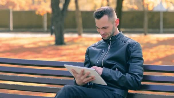 Mann im Park benutzt großen weißen Tablet-PC — Stockvideo