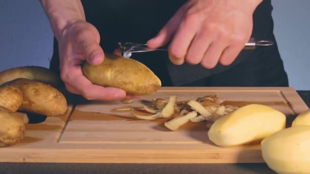 Man is Peeling Potato in a Kitchen — Stock Video