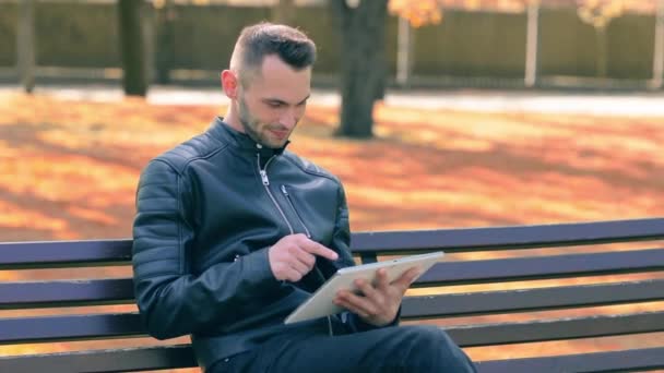 Hombre en un parque usando Big White Tablet PC — Vídeo de stock