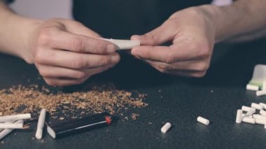 El yapımı sigarayı yuvarlayan adam.