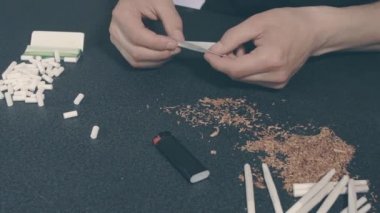 El yapımı sigarayı yuvarlayan adam.