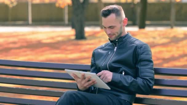 Homem em um parque usando grande tablet branco PC — Vídeo de Stock