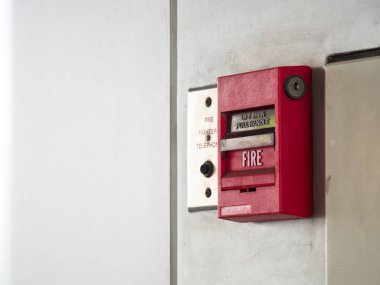 Basma düğmesi geçiş, yangın alarm alarm ve güvenlik sistemi ile yangın söndürücü liman için gri duvar.