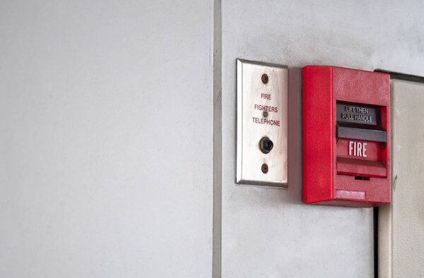Кнопка включения, пожарная сигнализация на серой стене для сигнализации и системы безопасности с портом огнетушителя
.