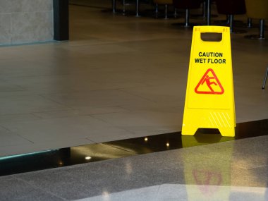 Uyarı ıslak zemin mağaza restoranda gösteren işareti ile sarı plastik koni