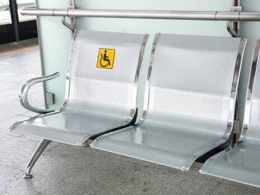 Paslanmaz çelik sandalye engelliler için tren hizmetleri kullanımını kolaylaştırmak için Engelli tabela ile tren istasyonunda.