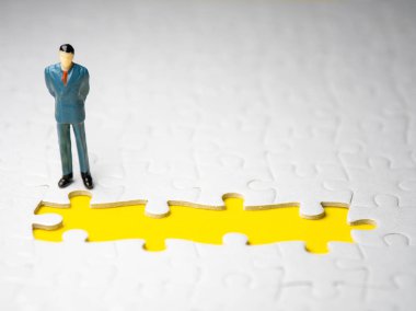 parça yapboz sarı arka plan üzerinde eksik önünde duran işadamı.