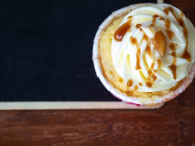 üstten görünüm vanilyalı kek ve karamel Tepesi ve yazı tahtası ahşap masa üzerinde bir arka plan olduğunu.