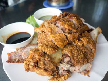 Bir tabakta sebze ve baharat soslu çıtır çıtır kızarmış domuz bacak yerleştirilir