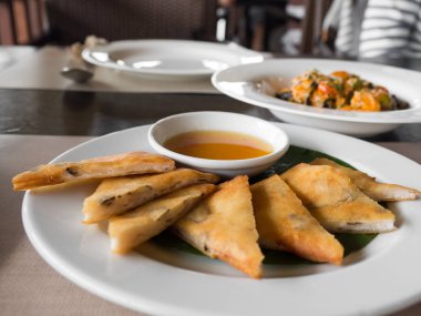 karides ve domuz etinin beyaz bir tabak içinde bir restoran ile doldurulmuş bir gevrek bahar rulo yakın çekim