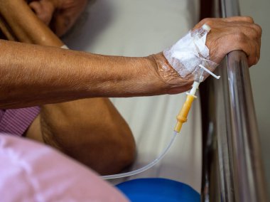 El hasta yaşlı adam el hastanede serum fizyolojik intravenöz (IV) çözüm ile kapatın. hasta ile iğne tak tıp için serum fizyolojik ile kullanmak için.