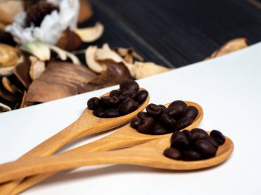 Kahve çekirdekleri boş not defterindeki bir wooden spoon ve ahşap masaya kurutulmuş çiçek yerleştirilir.