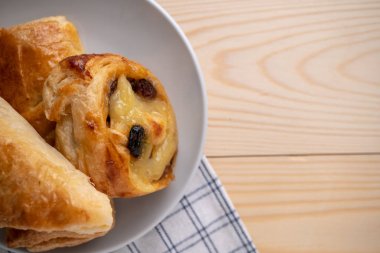 Sabah kahvaltısı için ahşap tepsi ve peçeteye yerleştirilmiş taze çörekler ve turtalar. metin için boşluk kopyala.
