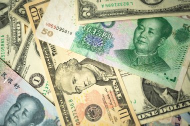 Abd dolar yığını ve Çin yuan banknotları masada ABD ve Çin arasında bir ticaret savaşı kavramı