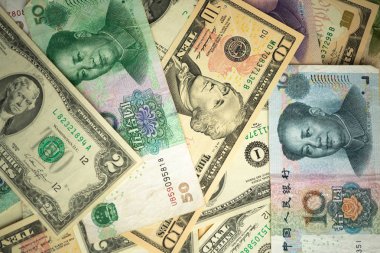 Abd dolar yığını ve Çin yuan banknotları masada ABD ve Çin arasında bir ticaret savaşı kavramı
