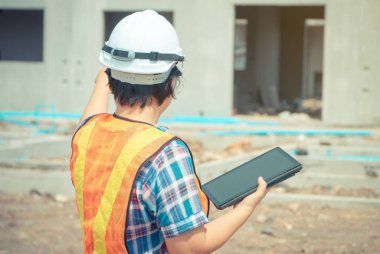 Asyalı kadın mühendisliği, inşaat alanlarının doğruluğu ve plana uygun olarak teftiş edilmesinde kullanılmak üzere bir tablet tutuyor. Kadın ve erkek arasında eşit haklar kavramı