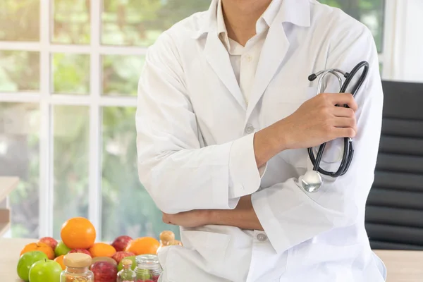 Medico Nutrizionista Seduto Sulla Scrivania Con Frutta Bottiglia Vitamina Clinica — Foto Stock