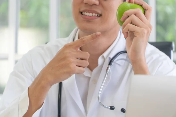 医師や栄養士は緑のリンゴを保持し クリニックでリンゴに指を向け 健康的な食事 健康のための処方箋としての栄養食品の概念 果物は薬です — ストック写真