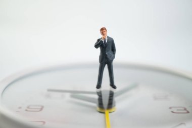 Şekil işadamları düşünme ve saat yüzünde zaman gösteren beyaz saat yüzünde ayakta. Zaman yönetimi kavramı.