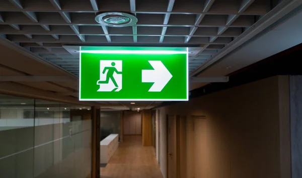 Ofiste Tavanda Yeşil Yangın Çıkışı Işaret Asmak — Stok fotoğraf