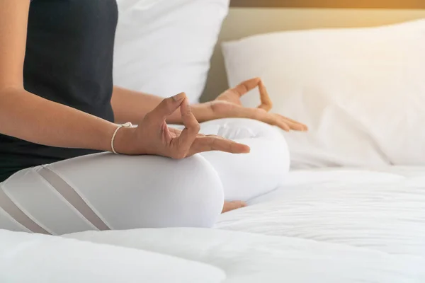Middle aged women doing yoga easy pose to meditation with yoga in bedroom at the morning, adho mukha svanasana pose. Concept of exercise and relaxation in the morning.