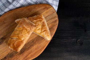 Sabah kahvaltısı için ahşap tepsi ve peçeteye yerleştirilmiş taze çörekler ve turtalar. metin için boşluk kopyala.
