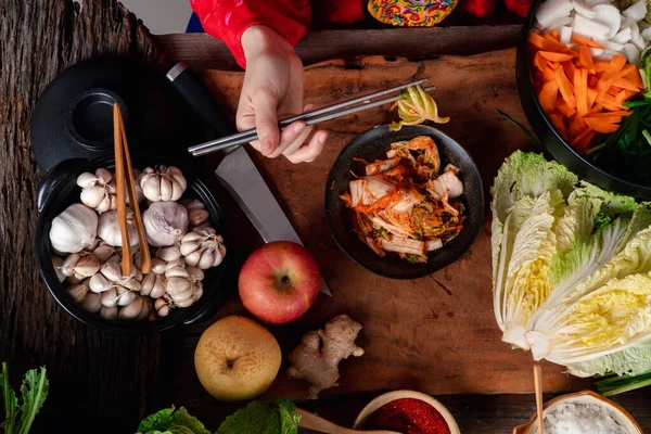 Asian women wearing Korean traditional costumes (hanbok) are mixing fresh stir-fry and kimchi ingredients with ingredients such as salt, garlic, gochugaru, fresh vegetables. — Stock Image Asian Women Wearing Korean Traditional Costumes Hanbok Mixing Fresh Stir Royalty Free Stock Photos