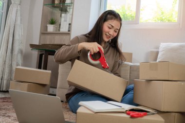 Genç Asyalı mutlu girişimciler kasetçaları kullanarak paketleri müşterilere ulaştırmak için kapatıyorlar. Küçük işletme sahibi ve çevrimiçi iş kavramlarında başarı.