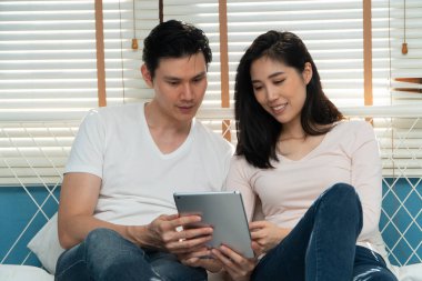 Balayı için seyahat yerleri ve kitap seyahatleri bulmak için birlikte tablet arayan mutlu genç bir çift. Kolaylık için teknoloji kavramı, evlilikten sonra mutluluk.