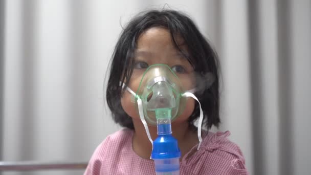 Menina asiática ter uma máscara de oxigênio e respirar através de um nebulizador no hospital. Conceito de bronquite, tratamento respiratório e médico. — Vídeo de Stock