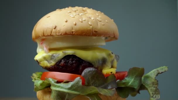 Hamburger proaspăt preparat de casă cu legume proaspete, salată verde, roșii, brânză pe o placă de tăiere. Spațiu liber pentru text — Videoclip de stoc
