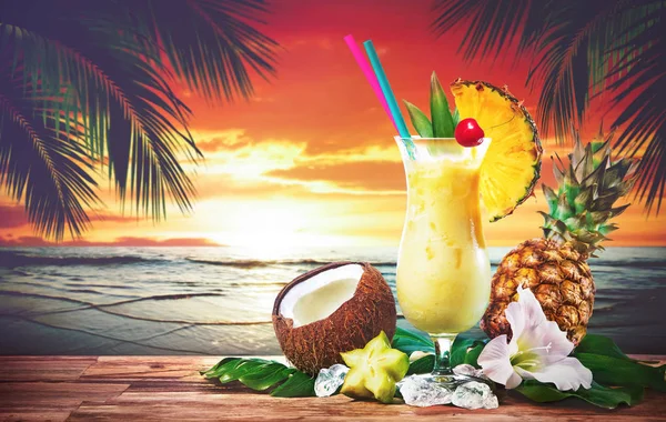 ピニャ コラーダ パイナップルとココナッツ ビーチにサンセットで提供しています新鮮なカクテルを飲む — ストック写真