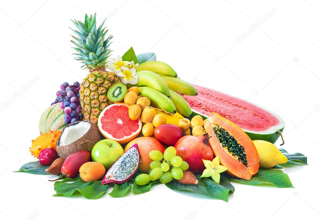 Assortment of tropical fruits with palm leaves and exotic flowers isolated on white