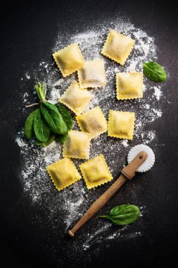 Ispanak ve ricotta koyu arka planda, üstten görünüm ile mantı