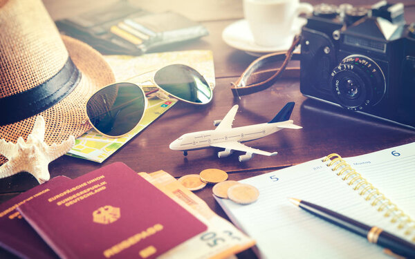 Travel planning concept. Accessories, passports, luggage, the cost of travel maps prepared for the trip on wooden table