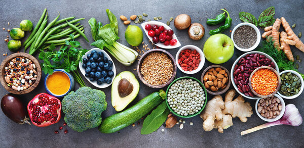 Здоровый выбор продуктов питания с фруктами, овощами, семенами, суперпищей, зерновыми на сером фоне