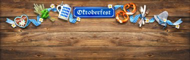 Oktoberfest için rustik arka plan beyaz ve mavi kumaş, Bavyera şapka, hop, zencefilli, bira stein ve ahşap masa üzerinde çubuk kraker ile