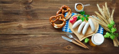 Çubuk kraker, tatlı hardal ve rustik ahşap masa bira Bavyera sosis. Oktoberfest menü
