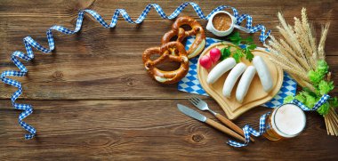 Çubuk kraker, tatlı hardal ve rustik ahşap masa bira Bavyera sosis. Oktoberfest menü