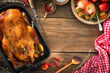 Kekik ve rustik ahşap masa üzerinde elma ile Noel ördek kızartma