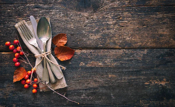 从落下的叶子和果实与旧木桌上的老式的地方设置的秋天背景 感恩节的概念 — 图库照片