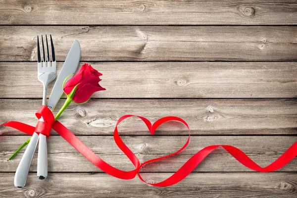 木の板にハート型の赤いリボンで縛られ銀器 コンセプト バレンタインデー ディナー レストラン パーティーお祝い — ストック写真