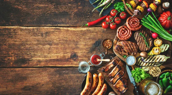 Grilled meat and vegetables on rustic wooden table. Barbecue menu