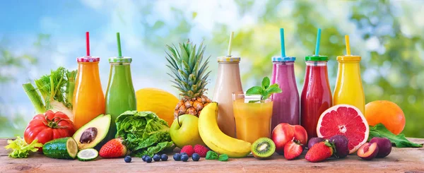 Colorful freshly squeezed fruits and vegetables smoothies with ingredients for healthy eating. Detox, dieting or healthy food concept