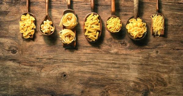 Verschillende Pasta Lepels Houten Achtergrond Bovenaanzicht Met Kopie Ruimte — Stockfoto