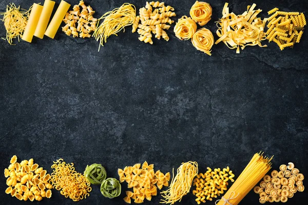 Verschillende soorten pasta over stenen achtergrond. — Stockfoto