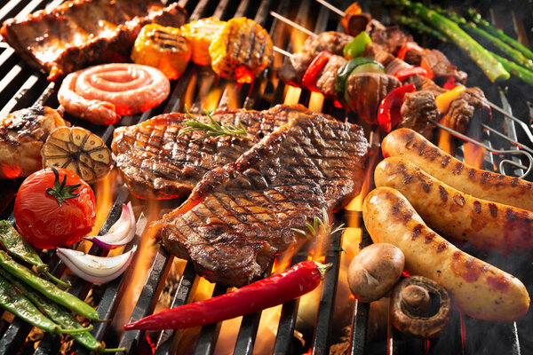 Delicious grilled meat with vegetables sizzling over the coals o